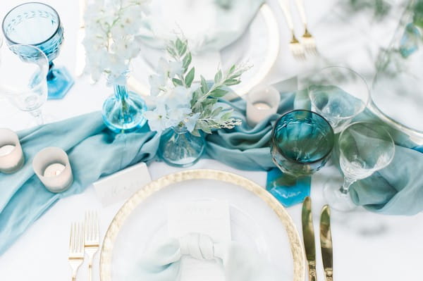 Blue silk runner and blue glassware on wedding table