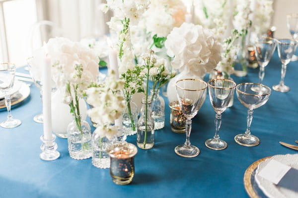 Bottles and vases of white flowers on wedding table