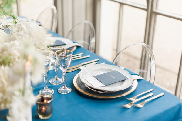 Place setting on wedding table with navy blue tablecloth