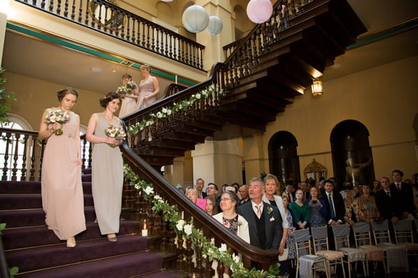 Bridesmaids walking down stairs at Kings Weston House
