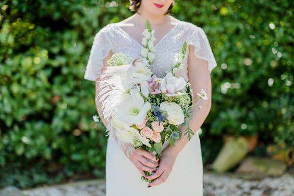 Bride holding bouquet with ostrich feathers