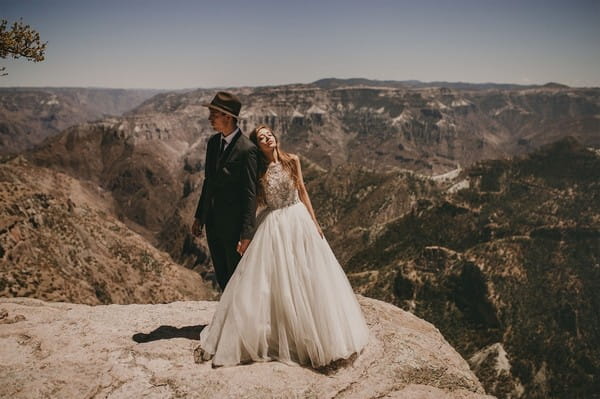 Bride and groom standing on cliff enge - Picture by Pablo Laguia