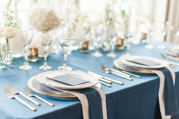 Place settings on navy blue styled wedding table