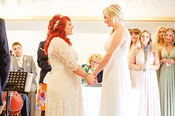 Brides holding hands facing each other