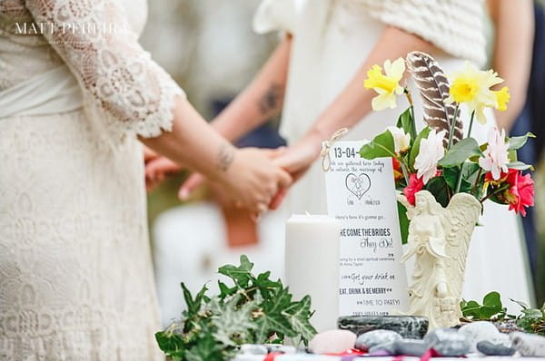 Bride's holding hands behind handfasting table