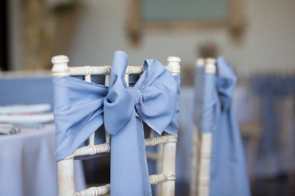 Blue bow tied to back of wedding chair