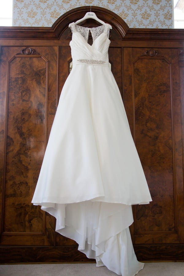 Wedding dress hanging on front of wardrobe