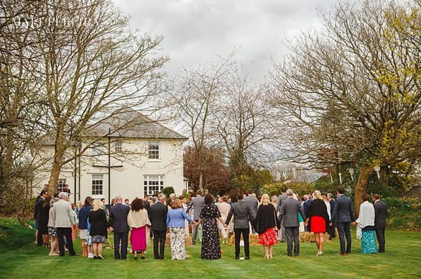 Wedding guests standing holding hands