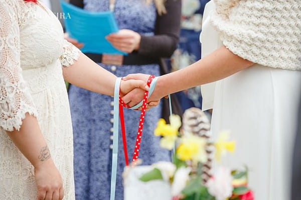 Brides' hands tied together