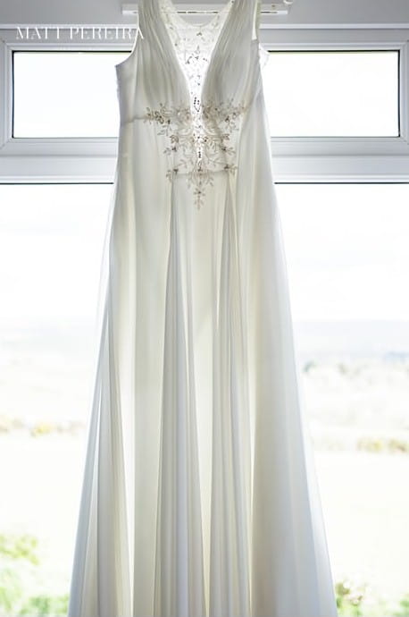 Wedding dress hanging in front of window