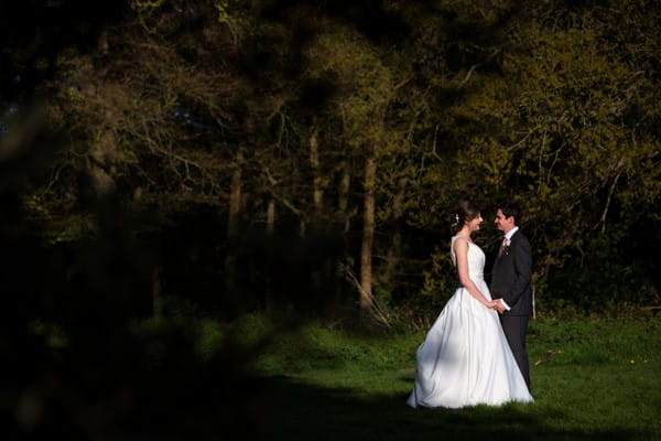 Bride and groom facing each other in garden at Kings Weston House