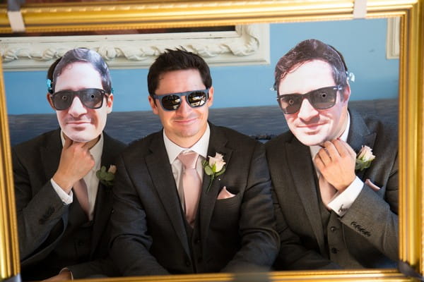 Groom with groomsmen wearing masks of his face