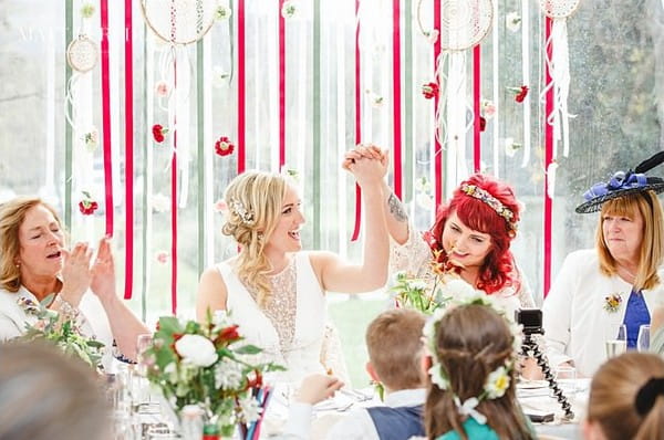 Brides holding hands in the air