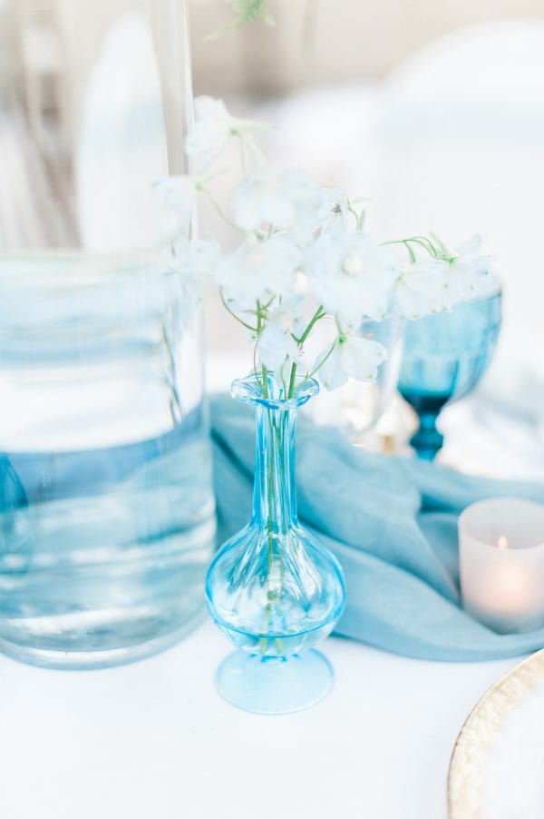 Small blue vase of flowers on wedding table