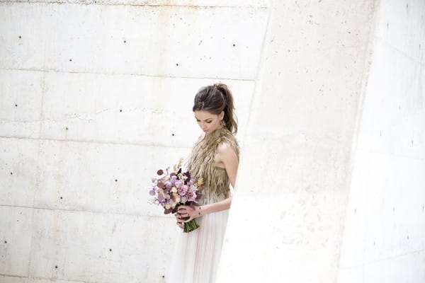 Bride holding purple bouquet