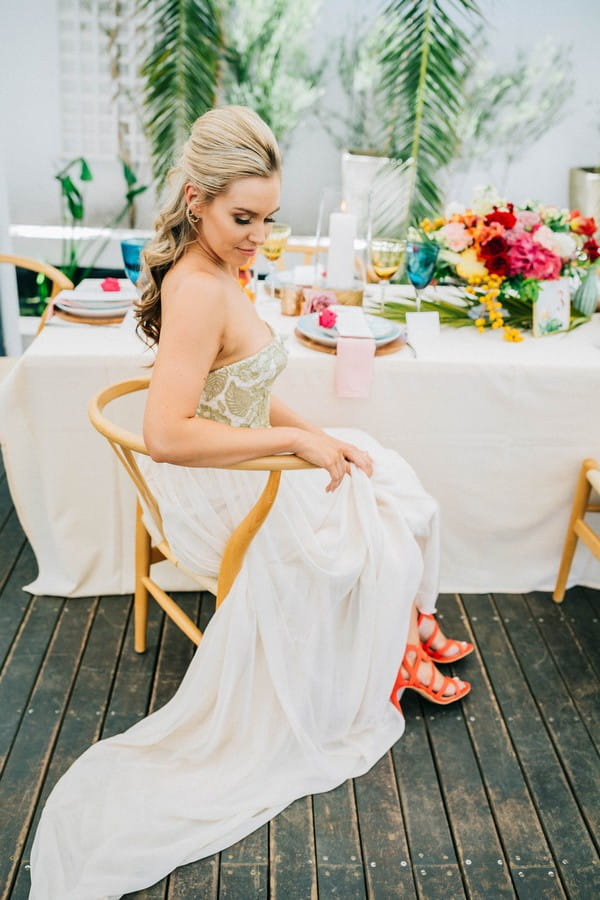 Bride sitting next to wedding table