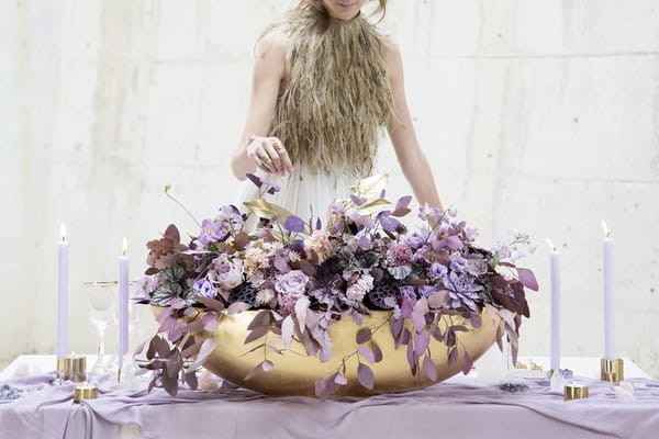 Large purple floral display in gold trough