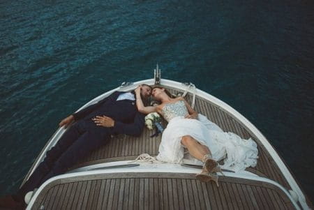 Bride and groom laying on front of a boat - Picture by Katja & Simon Photography