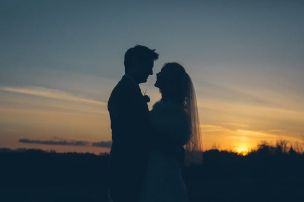 Silhouette of bride and groom as sun sets - Picture by Robin Ball Photography