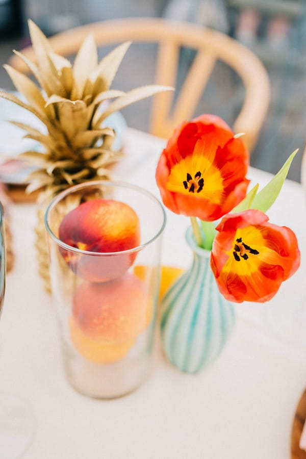 Bright orange flowers and fruit on wedding table