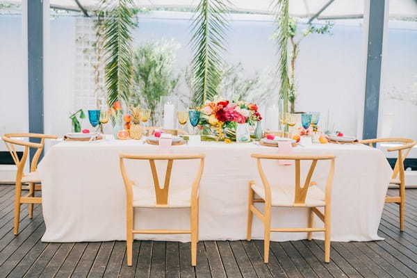 Tropical styled wedding table with palm leaves backdrop