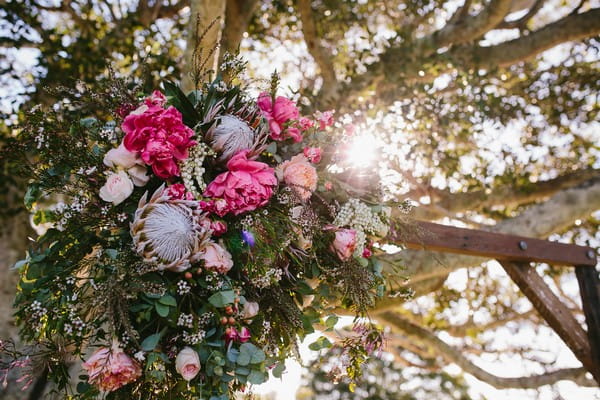 Large floral bouquet tied to wedding ceremony structure