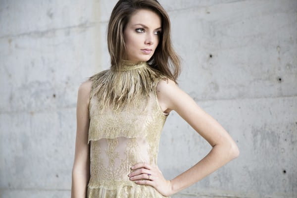 Bride in gold wedding dress with hand on her hip