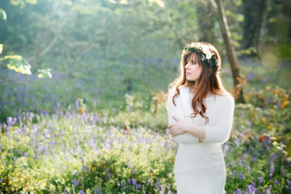 Bride with flower and foliage crown standing in woodland