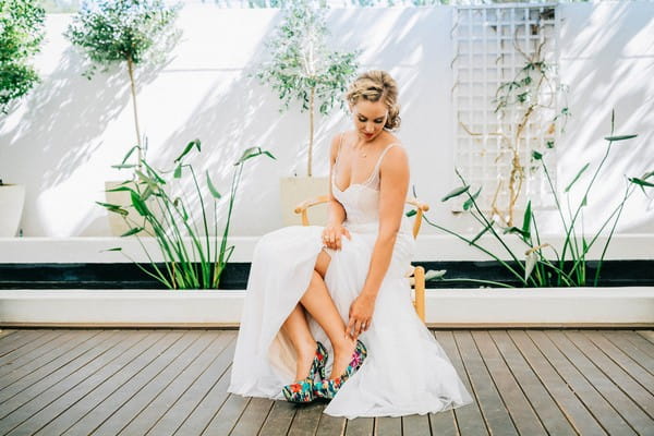 Bride looking down at colourful shoes