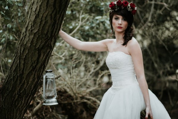 Bride leaning against tree