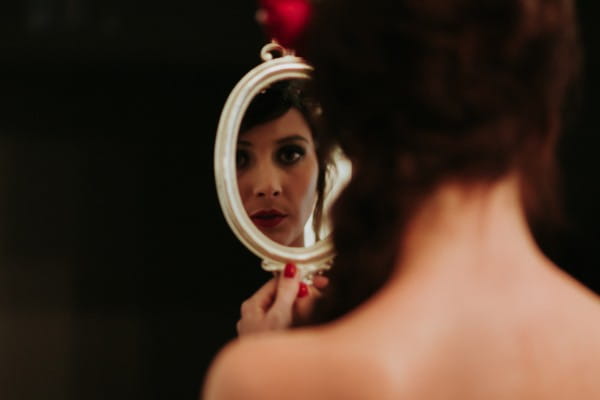 Bride looking in hand mirror