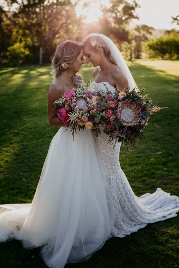 Two brides touching heads