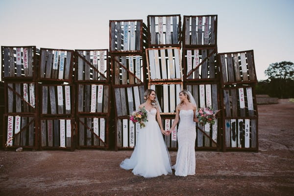 Two brides in front of old pallets