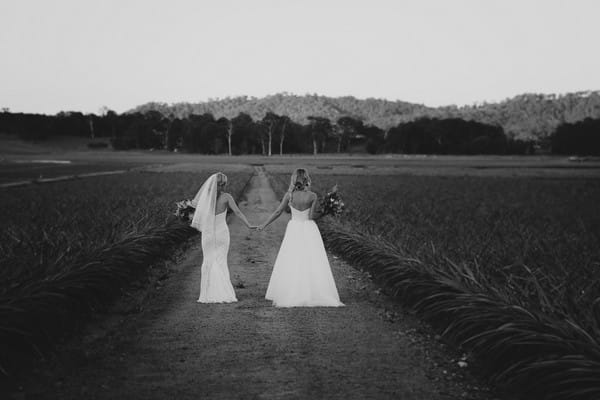 Two brides walking in grounds of Yandina Station