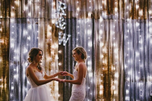 Brides facing each other holding hands