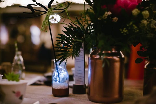 Copper vase and glass bottle table decor