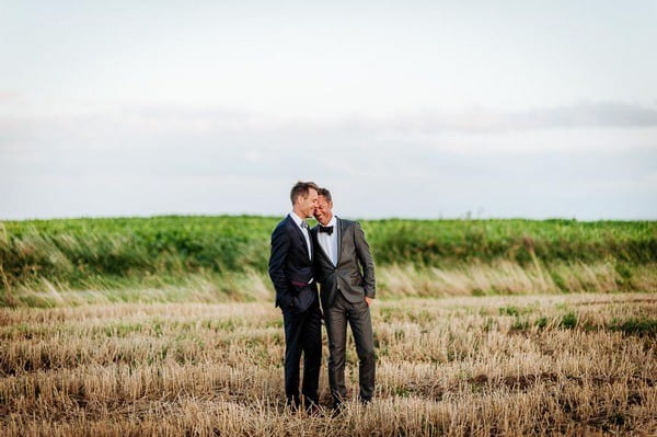 Two Grooms in Field Wearing Different Colour Suits