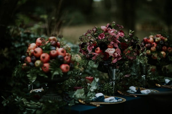 Three foliage and fruit displays on wedding table