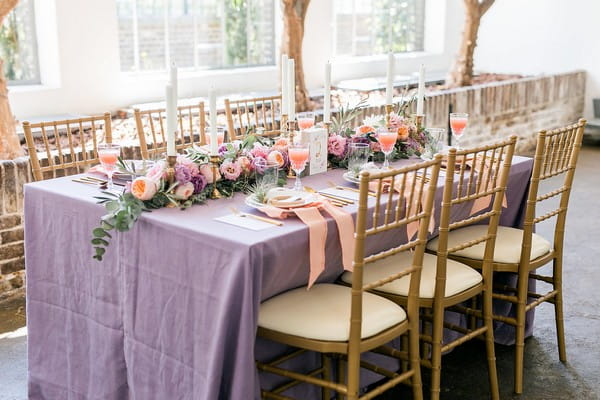 Wedding table with violet tablecloth and peach details