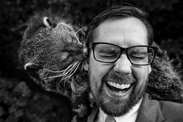 Groom laughing as animal nuzzles his ear - Picture by Bryan Surgener Photography