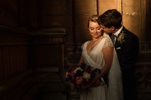 Groom standing behind bride with arms around her waist - Picture by Becky Harley Photography