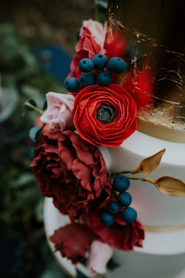 Red flower and berry wedding cake decoration