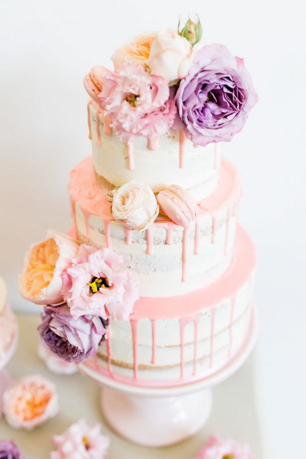 Drip wedding cake with violet and peach flowers