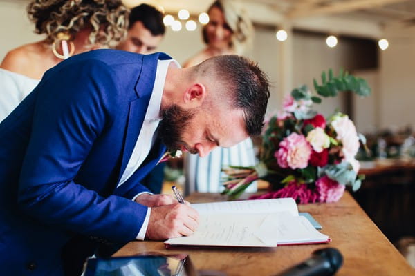 Groom signing marriage register