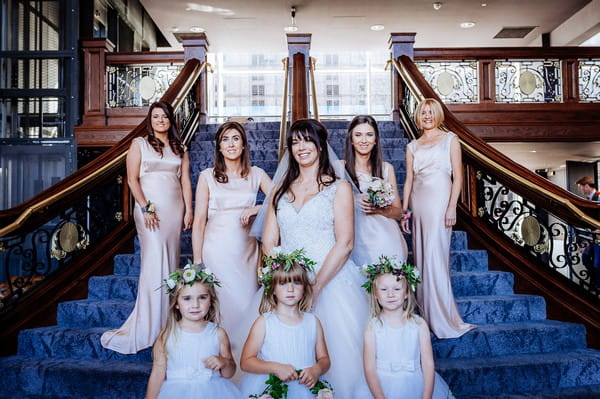 Bride, bridesmaids and flower girls on stairs inside Titanic Hotel Liverpool