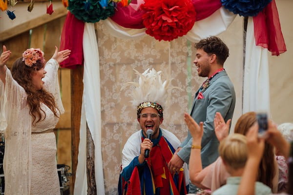 Celebrant enthusiastically announcing bride and groom as husband and wife