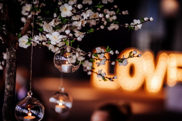 Tea light in bauble hanging from tree