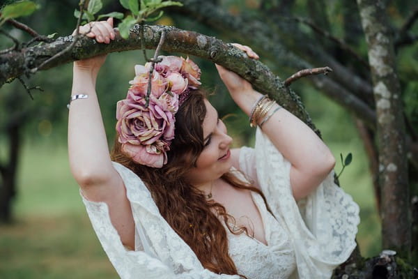 Bride holding on to tree branch