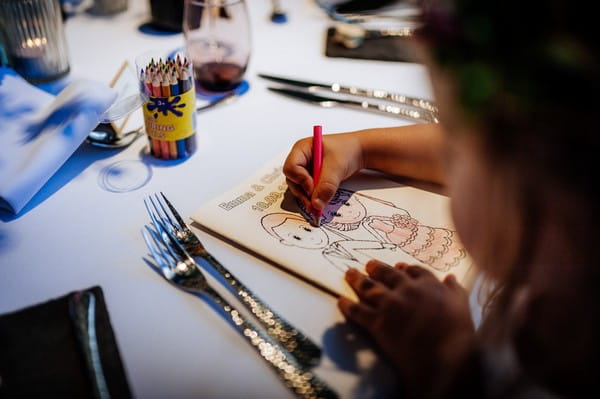 Child colouring in wedding activity book