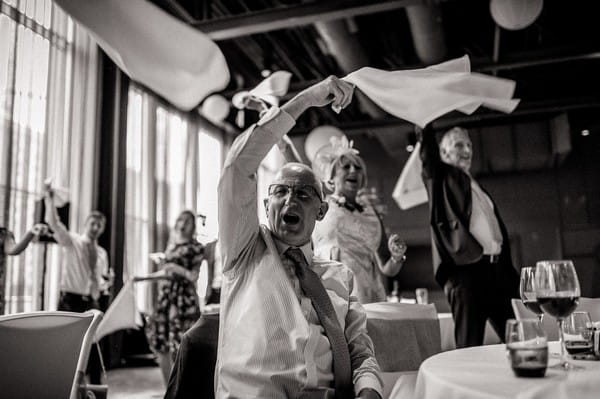 Wedding guests waving napkins over their heads